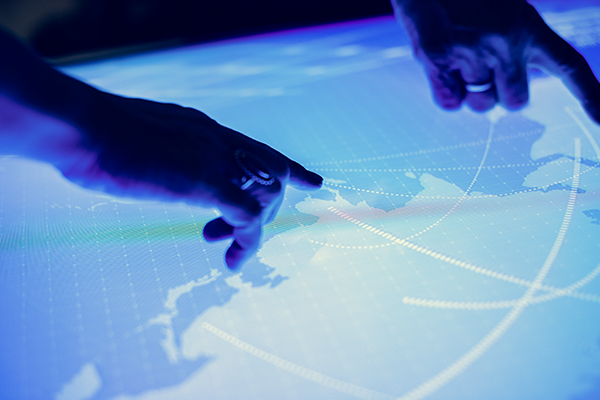 two hands point to a display with a map